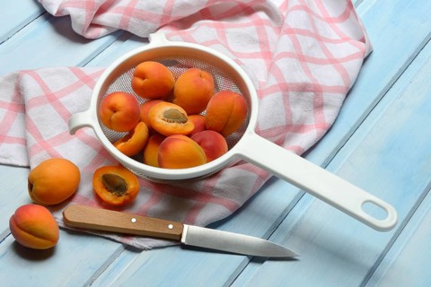 Apricots in colander, halved, Prunus armeniaca