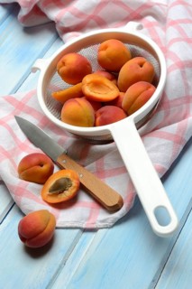 Apricots in colander, halved, Prunus armeniaca