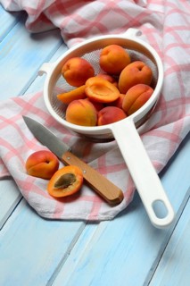 Apricots in colander, halved, Prunus armeniaca
