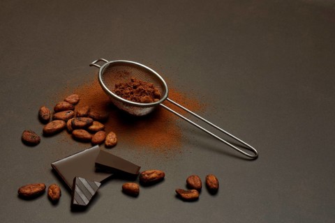 Kitchen sieve with cocoa powder and chocolate, cocoa and cocoa beans