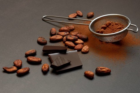 Kitchen sieve with cocoa powder and chocolate, cocoa and cocoa beans