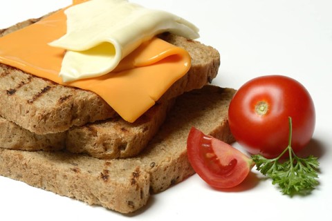 Processed cheese, slices of processed cheese on toast and tomato