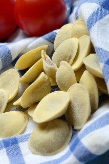 Anolini, filled pasta pockets on kitchen towel, pasta variety from Italy, Anolini piacentini