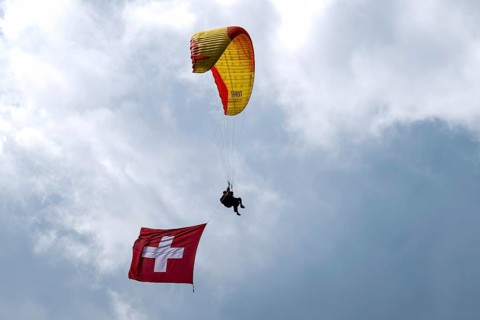Paragliding tandem flight with Swiss flag, Interlaken, Switzerland