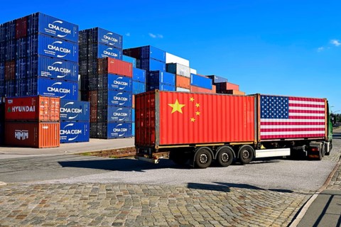 Container with USA and China flag on a lorry, stacked containers in the background, customs dispute