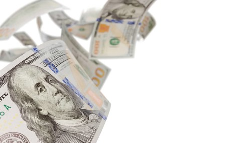 Randomly falling U.S. 100 dollar bills isolated on a white background
