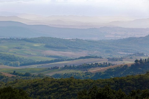 Hilly Tuscan landscape under a cloudy sky, wide open spaces and fields