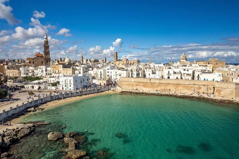 Old town of Monopoli with the cathedral, city walls and Cala Porta Vecchia beach seen from above,