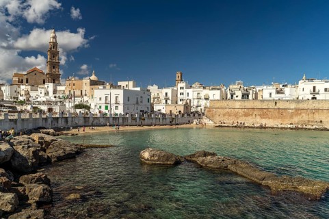 City view of Monopoli with the cathedral, city wall and the beach Cala Porta Vecchia, Apulia, Italy
