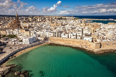 Old town of Monopoli with the cathedral, city walls and Cala Porta Vecchia beach seen from above,