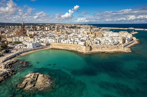 Old town of Monopoli with the cathedral, city walls and Cala Porta Vecchia beach seen from above,