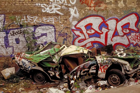A crashed car in front of the Berlin Wall, in the 1990s, Berlin, Germany