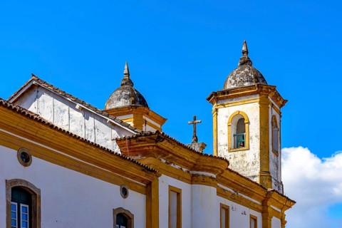 Tower and crucifix of a historic baroque church in the city of Ouro Preto in Minas Gerais, Ouro