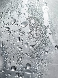 Drops of water on plastic bottle, neutrally illuminated, detailed view