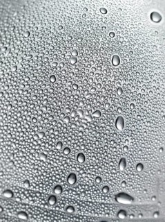 Drops of water on plastic bottle, neutrally illuminated, detailed view