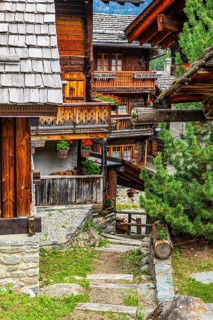 Winding wooden houses with flower-decorated balconies in the historic centre of Grimentz, Val