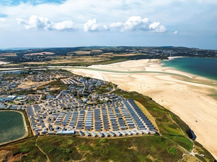 Holiday homes over Hayle Beach and Hayle Estuary from drone, St Ives Bay, Cornwall, England, United