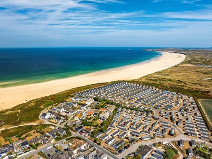 Holiday homes over Hayle Beach and Hayle Estuary from drone, St Ives Bay, Cornwall, England, United