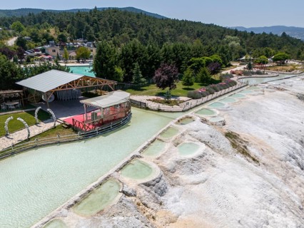 Panoramic view of limestone terraces next to a green park with a red platform, aerial view, Akkaya