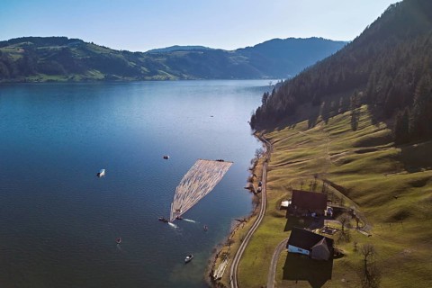 Forestry workers float a raft of felled tree trunks from the Bergmatt across the Ägerisee to the