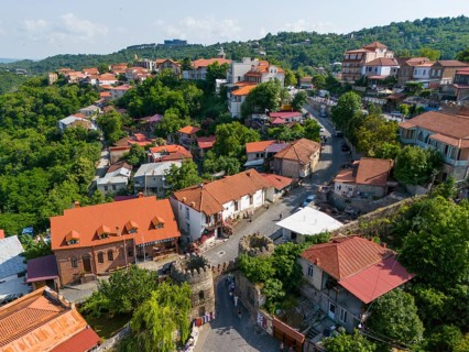 Picturesque village with characteristic red roofs, surrounded by green vegetation and small