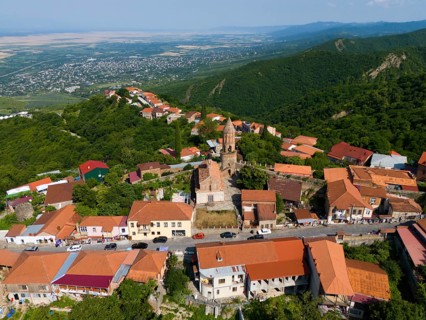 Panorama of a hilly town with a central church and traditional roofs, aerial view, Sighnaghi,