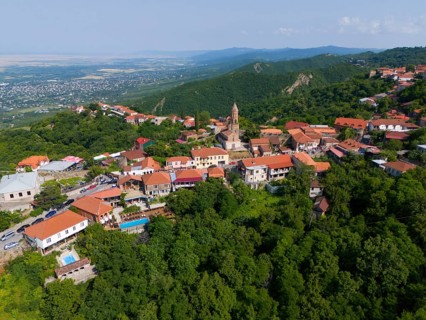 Sweeping view over a hilly region with town and traditional buildings, aerial view, Sighnaghi,