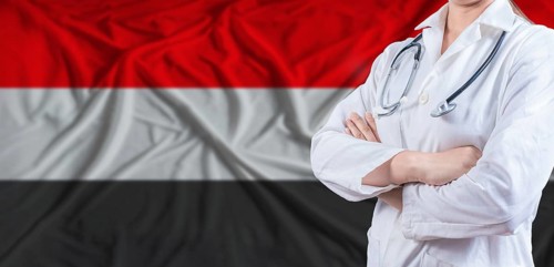 Doctor with crossed arms on Yemen flag. Yemeni health and care concept. Female doctor on Yemen flag