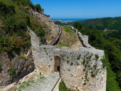 Old castle ruins amidst lush vegetation and under a clear sky, aerial view, Ünye Castle, Ünye