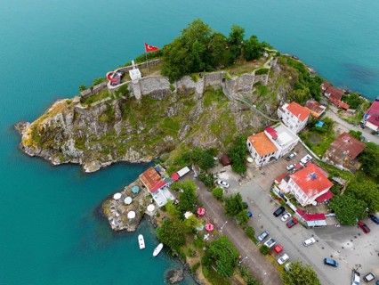 Aerial view of a castle by the sea with Turkish flag and surrounding buildings, aerial view,