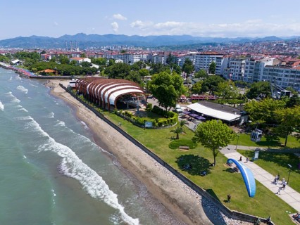 Aerial view of a coastal promenade with modern buildings and undulating beach sections, aerial