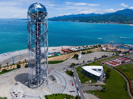 Steel construction tower overlooking the sea, Ferris wheel and surrounding coastline on a sunny