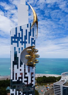Futuristic building with golden element and golden gondolas on the coast overlooking the sea,