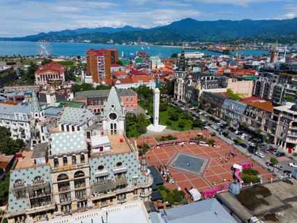 Historic architecture with large square, surrounded by mountains near the coast, aerial view,