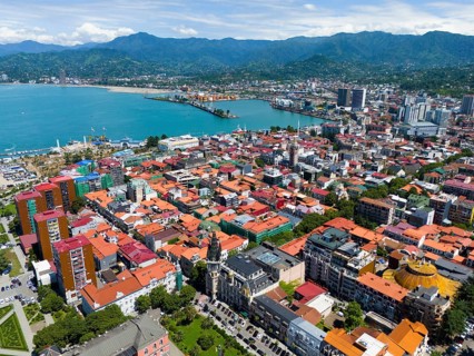 Panoramic view over the city with colourful roofs and mountains in the background, aerial view,