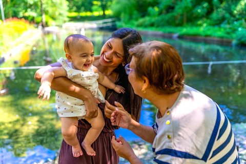 Latin family, including a grandmother, mother, and baby daughter, are enjoying quality time