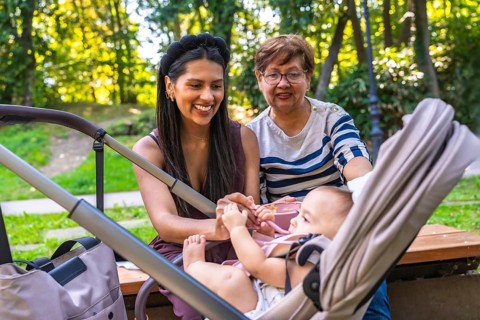 Grandmother, mother, and baby girl enjoying quality time together in a park, highlighting the joys
