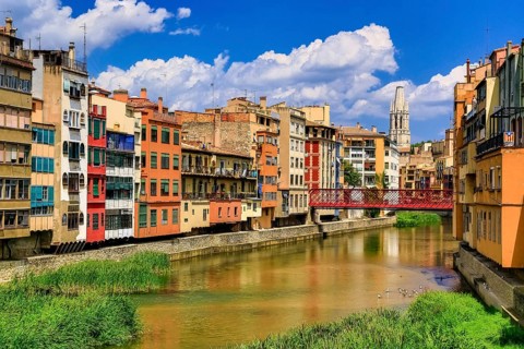 Red bridge over the river Onyar built by the Eiffel company, colourful facades over the river