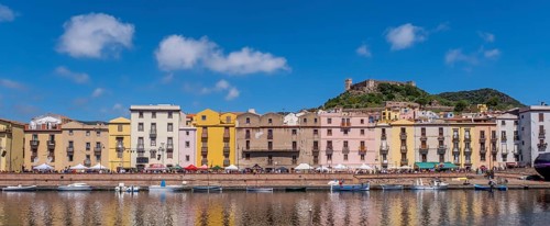 Sardinia, panoramic photo with houses and promenade on the river Temo, guests at the restaurants