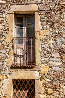 Sardinia, house facade with balcony and weathered wooden balcony door, brown balcony lattice, Santu