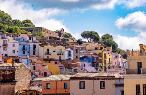 Sardinia, picturesque view of Bosa with pavilions on the promenade, residential buildings and