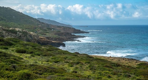 Sardinia, rugged coastal landscape by the sea, mountains, sea and more, blue sky with clouds,
