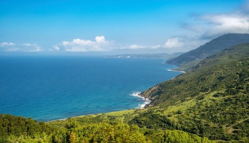 Sardinia, mountainous coastal landscape by the sea, blue sky with clouds, Bosa, Europe, Province of