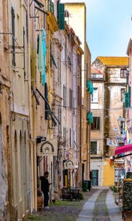 Sardinia, alley in the old town, fabric panels on the balconies and lamps, Alghero, Europe,