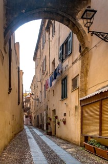 Sardinia, Narrow cobblestone alley and houses in the old town, Laundry by the window, Alghero,