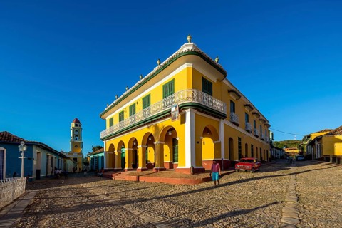 Centre of Trinidad Palacio Brunet, yellow palace with blue sky and the church Convento de San