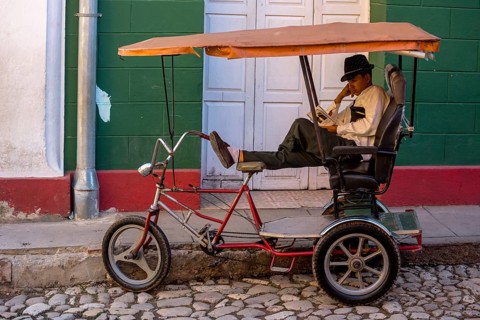 Rickshaw driver waiting for customers and reading a novel, Trinidad, Cuba, Sancti Spíritus, Sancti