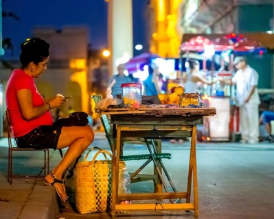 Private shop, street stall, trader counting money, streetlife in the city centre of Santa Clara at