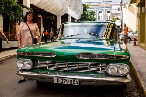 Vintage car, historic road cruiser, green Impala, streetlife in the city centre of Santa Clara at