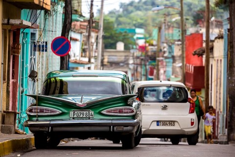 Vintage car, historic road cruiser, green Impala, streetlife in the city centre of Santa Clara at